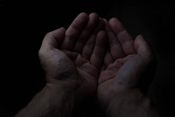 istock Two hands of  man in black background 1057543268