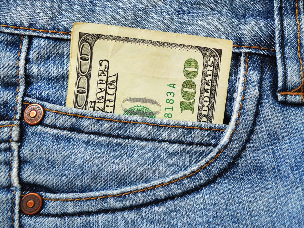 istock One hundred dollars bill in the front pocket of blue jeans 1057545334