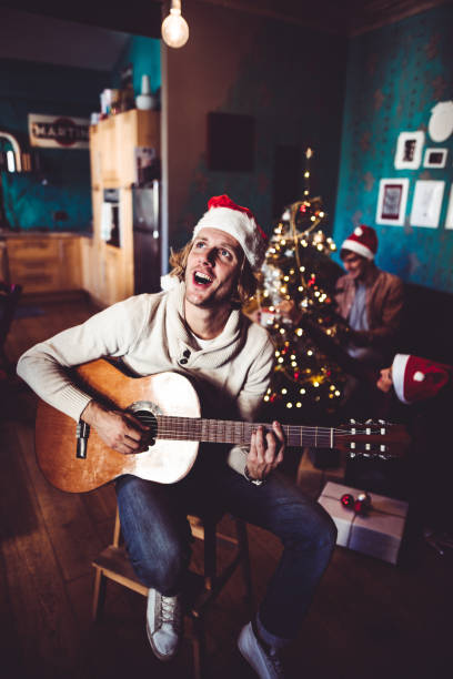 istock happiness man playing the guitar for christmas at home 1057546880