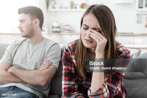 Couple Conflict Stressed Crying Female Sitting On Couch With Abusive Husband After Quarrel Ready To Divorce Stock Photo - Download Image Now