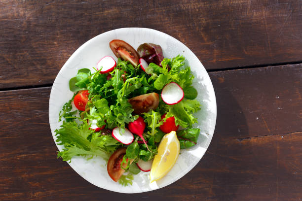 istock Bowl fresh vegetable salad on wooden table top view 1057550294