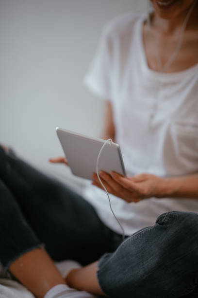 istock Young female using tablet in her living room 1057551618