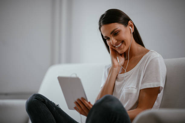 istock Young female using tablet in her living room 1057551944