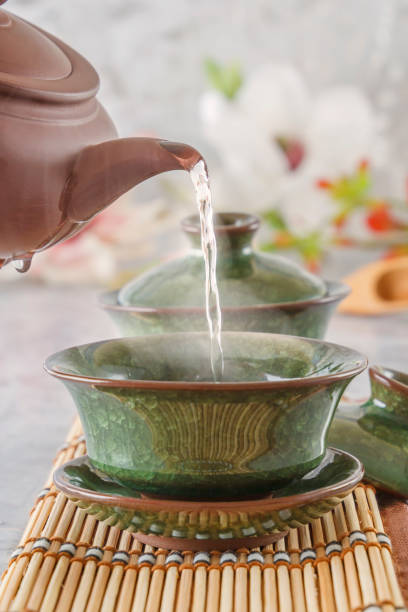 istock Boiling water from a ceramic kettle is poured into a traditional Chinese porcelain cup at a tea ceremony 1057556094