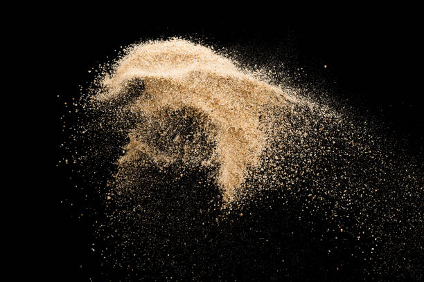 istock Sand flying explosion isolated on black background ,throwing freeze stop motion object design 1057556934