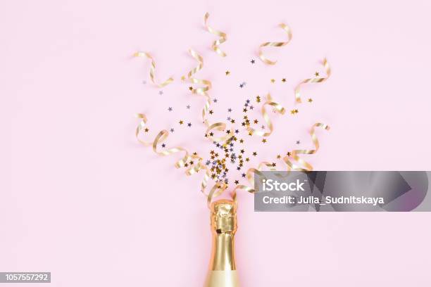 Champagne Bottle With Confetti Stars And Party Streamers On Pink Background Christmas Birthday Or Wedding Concept Flat Lay Stock Photo - Download Image Now