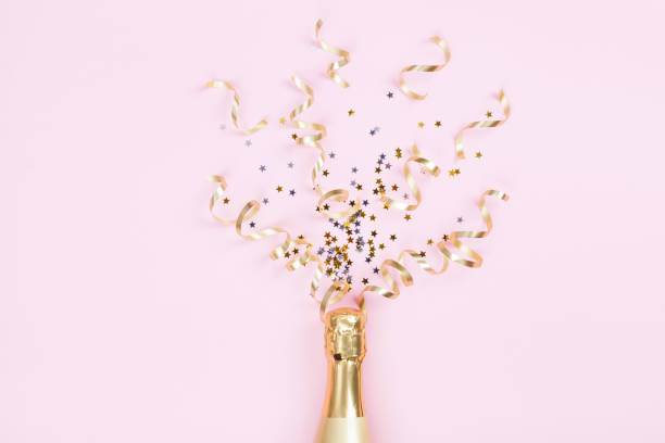бутылка шампанского со звездами конфетти и стримерами для вечеринок на розовом фоне. рождество, день рождения или свадьба концепции. кварт� - pink champagne стоковые фото и изображения