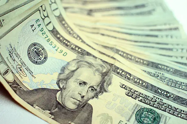 A row of U.S. twenty dollar bills fanned out -- focus on Andrew Jackson's face.