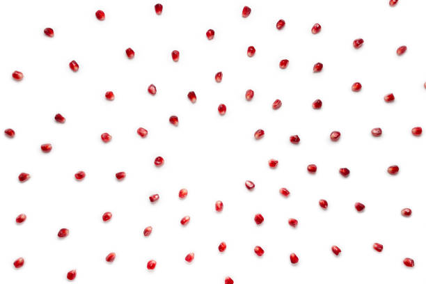 Fruit pomegranate seeds scattered in a chaotic manner, isolated on white background