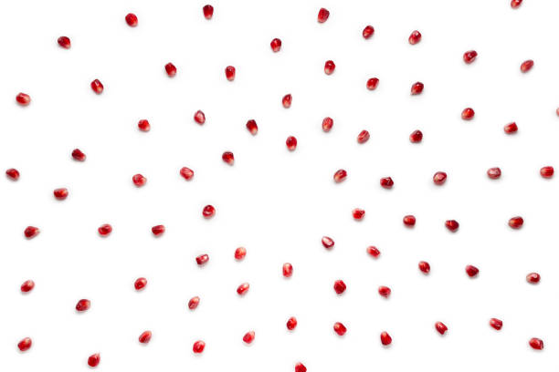 Fruit pomegranate seeds scattered in a chaotic manner, isolated on white background. Food background. stock photo