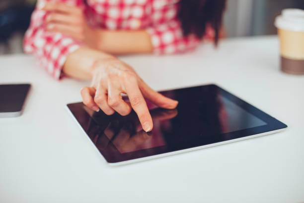 istock Young woman working with digital tablet.  Finger touching the screen. 1057566792