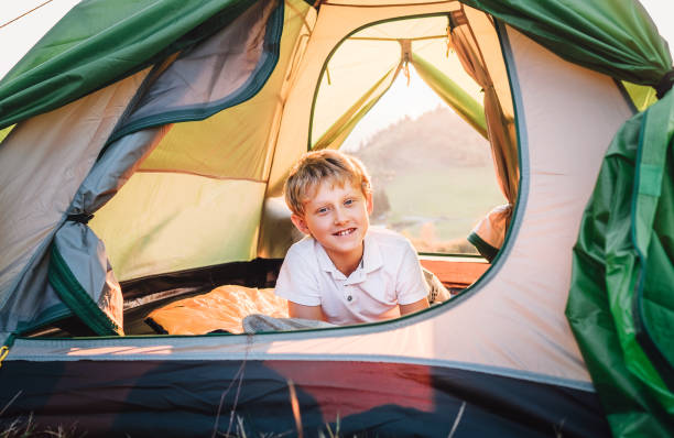 istock Happy smiling boy rest in tent at sunset time in mountain 1057570238