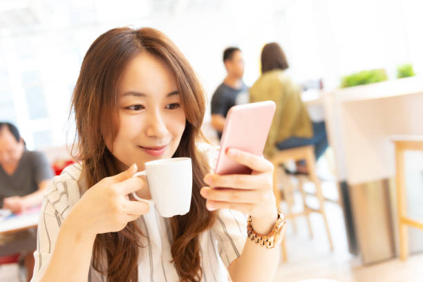 istock woman using smart phone in cafe. 1057572366