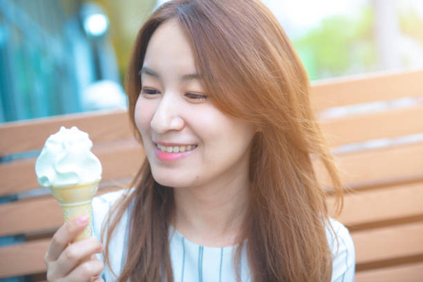 istock Pretty asian woman eating ice cream 1057572464