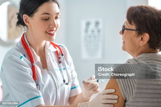 Doctor Vaccinating A Woman Stock Photo - Download Image Now - Vaccination, Injecting, Adult