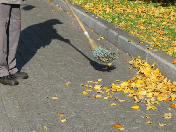 istock Janitor sweeping the fallen leaves on autumn street 1057582524