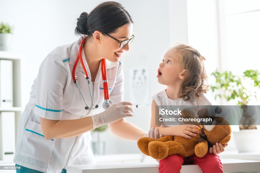 vaccination to a child A doctor making a vaccination to a child Child Stock Photo