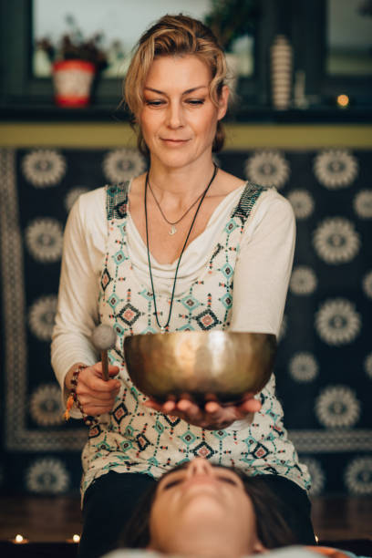 istock Therapist Playing Rin Gong By Young Woman At Spa 1057586294
