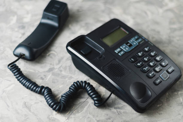 istock Desk phone with handset on old gray concrete table. Communication concept 1057590718
