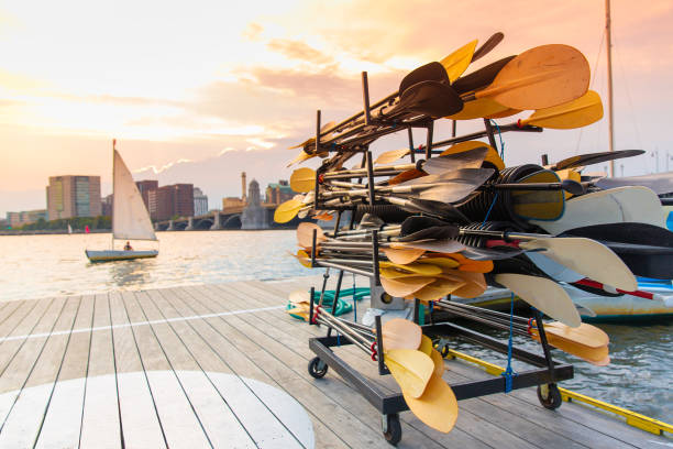 stand with paddles on a wooden pier by the river sailing boat at sunset. Blurred background, copy space for your text charles river stock pictures, royalty-free photos & images