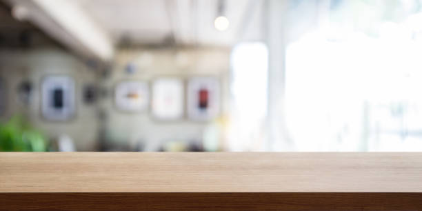 istock Empty wooden table top with blur coffee shop or restaurant interior background, Panoramic banner. 1057593942