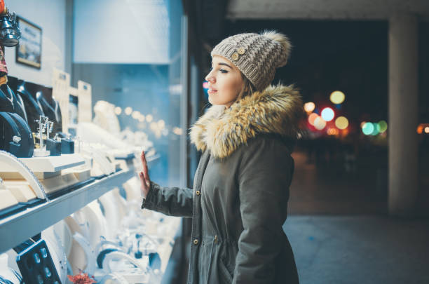 istock Woman window shopping at night 1057594686