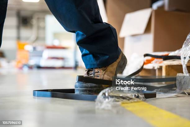 Un Tema De Seguridad Industrial Un Trabajador De Tropezar Con Una Papelera En Una Fábrica Foto de stock y más banco de imágenes de Caer