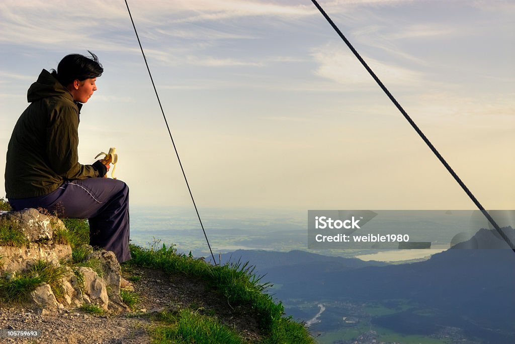 Mädchen Essen auf dem Berggipfel in der Morgensonne - Lizenzfrei Alpen Stock-Foto