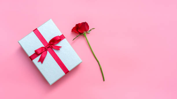 istock Red rose and gift box on a pink background. 1057599800
