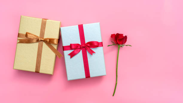 istock Red rose and gift box on a pink background. 1057600104