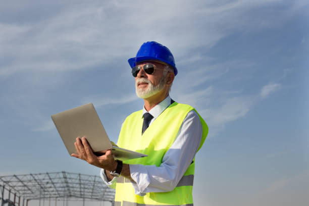 istock Senior engineer with laptop at building site 1057601004