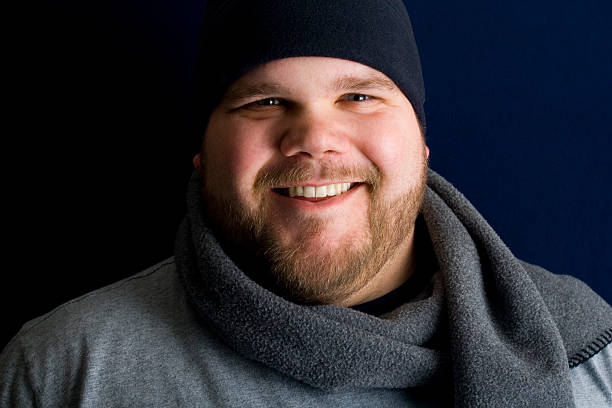 Young man smiling while wearing winter clothing.