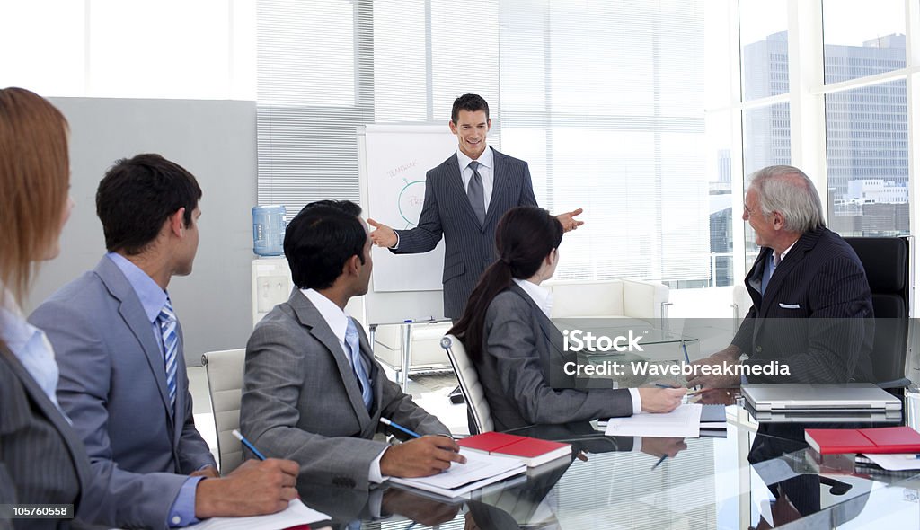 Confident businessman giving a presentation to his team Confident businessman giving a presentation to his team in the office Adult Stock Photo