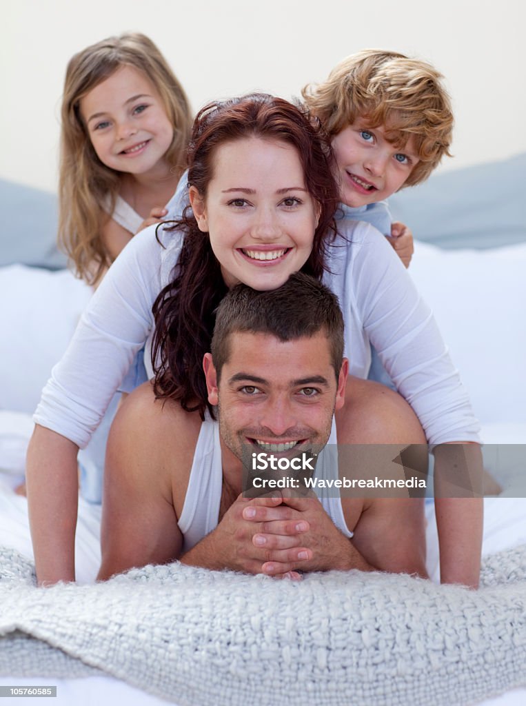 Portrait of happy family having fun in bed Portrait of happy family having fun in bed together Adult Stock Photo