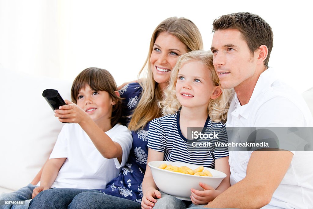 Famiglia sorridente a guardare la TV - Foto stock royalty-free di Famiglia