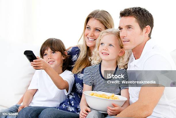 Famiglia Sorridente A Guardare La Tv - Fotografie stock e altre immagini di Famiglia - Famiglia, Guardare la TV, Adulto
