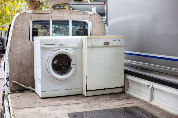 Old discarted dishwasher and washing machine on a vehicle  truck for recycling stock photo