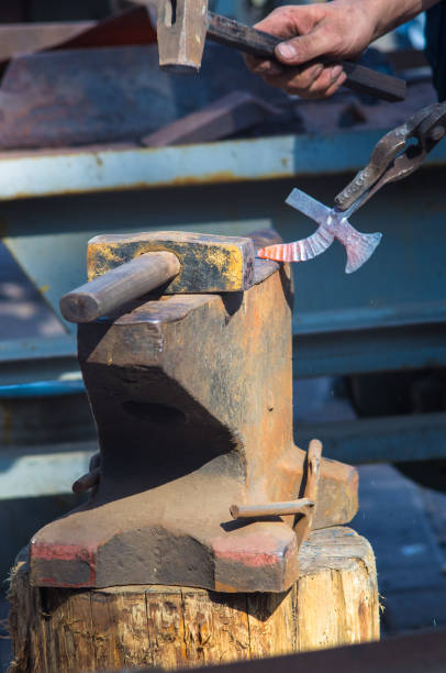 istock blacksmith performs the forging of hot glowing metal on the anvil 1057609584