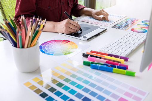 Imagen de mujer creativo diseñador gráfico trabajando en selección de color y dibujo en tableta gráfica en el lugar de trabajo photo