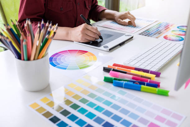 image of female creative graphic designer working on color selection and drawing on graphics tablet at workplace - design ilustrações imagens e fotografias de stock
