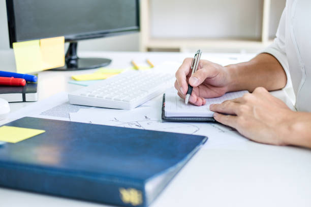 istock Businessman working writing business plan document and graphic designer with computer in office 1057617008
