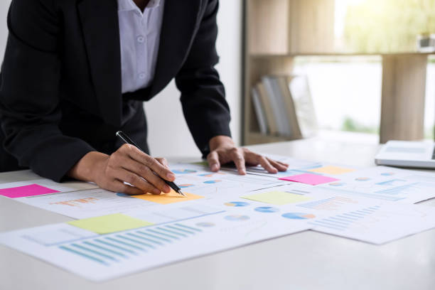 istock Female accountant calculations and analyzing financial graph data with calculator and laptop Business, Financing, Accounting, Doing finance, Economy, Savings Banking Concept 1057617350