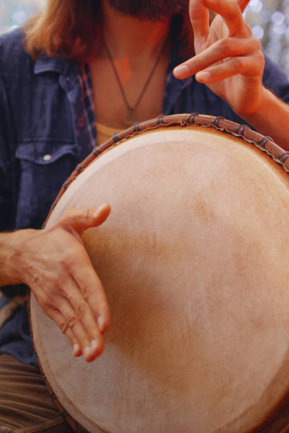 istock Hippie man playing djembe drum in autumn forest. 1057621190