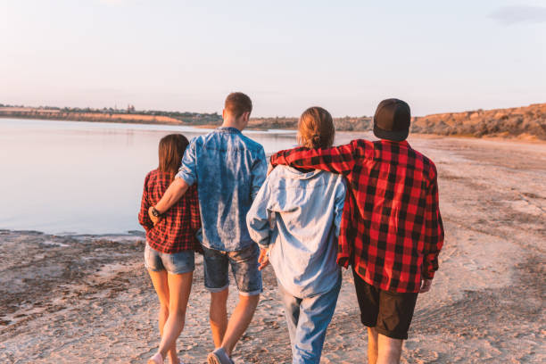 istock friends on beach together walking during sunset 1057623184