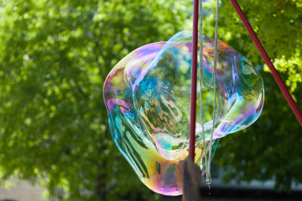 istock Arstist blowing colorful giant soap bubbles outdoor 1057623398
