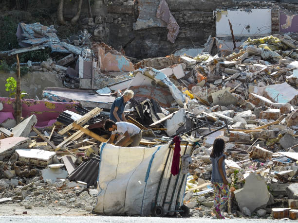 yaşlı, genç bir kız ve erkek yok edilen bir ev kalıntıları üzerine çöp toplamak - balat stok fotoğraflar ve resimler