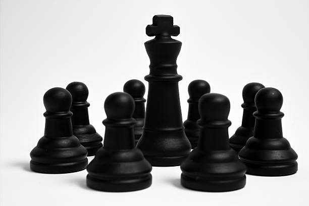 Black pawns and the king stock photo