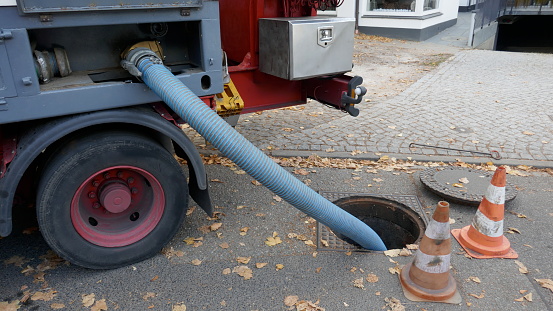 Bombeo del tanque de aguas residuales de un contenedor sanitario móvil en el sistema de aguas residuales photo