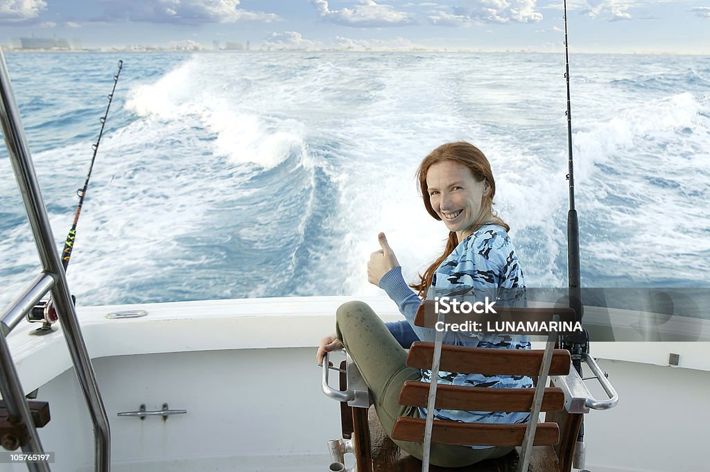 Pescadora gran partido en embarcación silla gesto de ok - Foto de stock de Mar libre de derechos