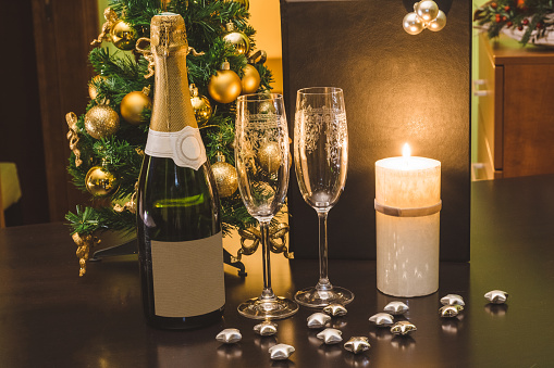 Christmas Decoration on the table with champagne, candles and glasses